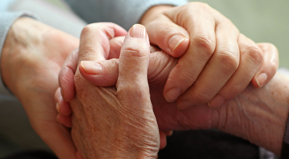 24 Hour Crisis image Elderly person holding hands with another person